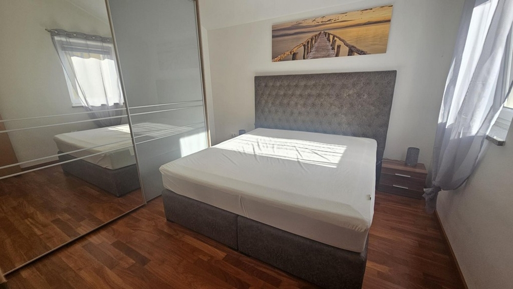 Spálňa s manželskou posteľou a veľkou zrkadlovou skrinkou