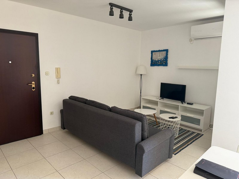 Obývacia izba s pohovkou a TV nábytkom