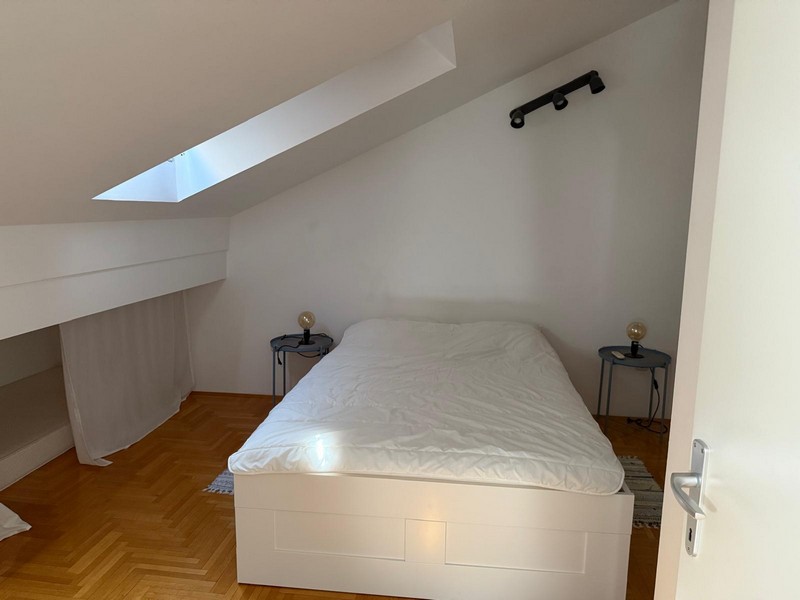 Podkrovná spálňa s posteľou a strešným oknom