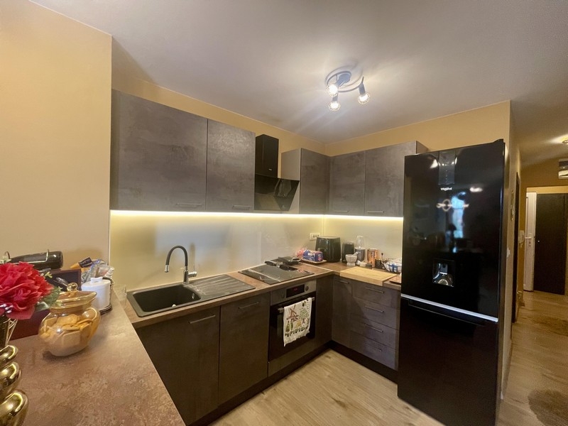 Moderne vybavená kuchyňa s tmavými prednými panelmi a veľkou chladničkou