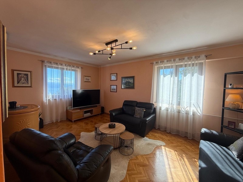 Svetlá obývacia izba s dvoma pohovkami a veľkými oknami