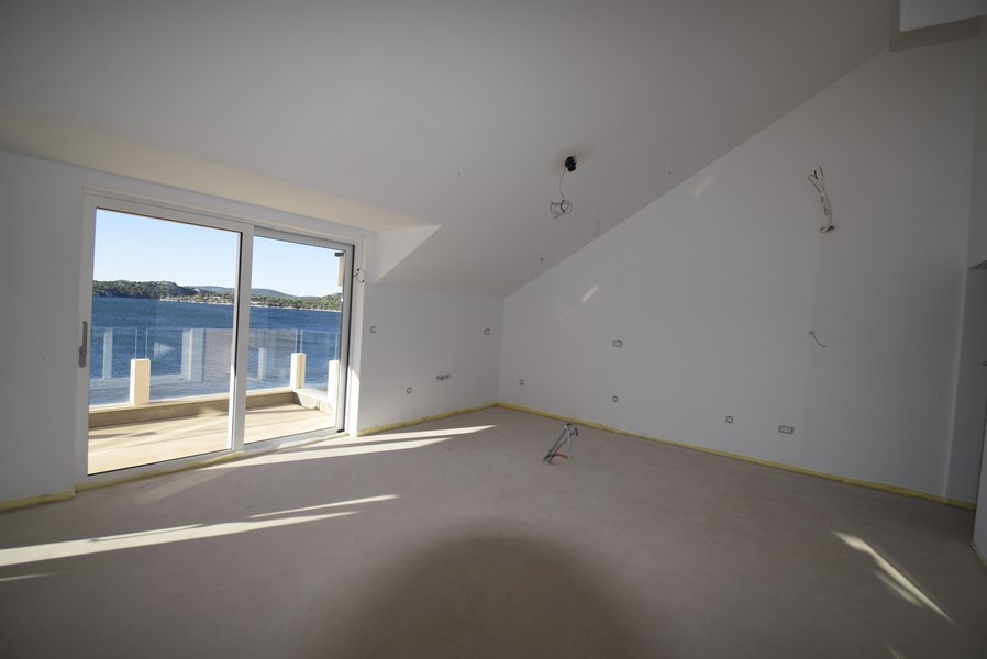 Obývacia časť v podkroví so vstupom na terasu a výhľadom na more