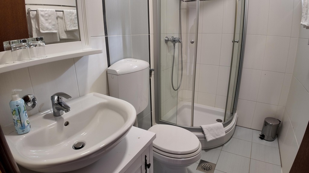 Kúpeľňa so sprchovým kútom a umývadlom - svetlá dlažba