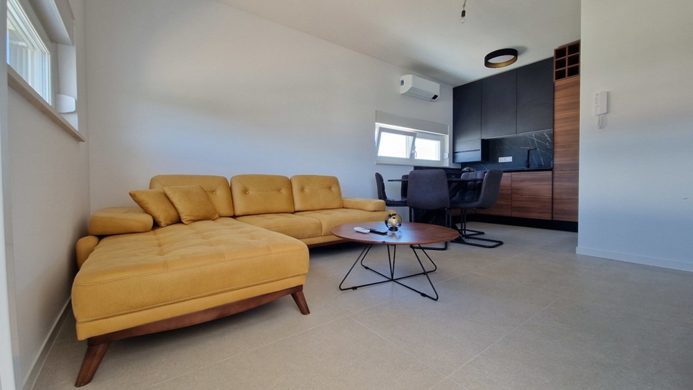 Obývacia izba so žltou pohovkou a jedálenským kútom