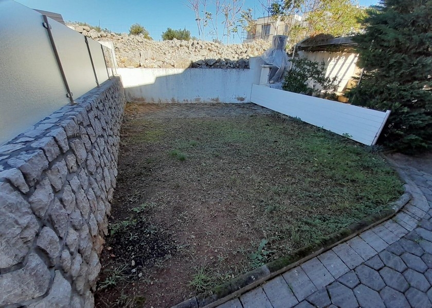 Malá záhrada s kamenným múrom a trávnikom