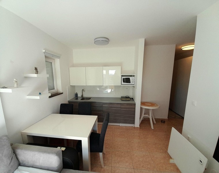 Svetlá obývačka a kuchyňa s dlažbou a vstupom do chodby