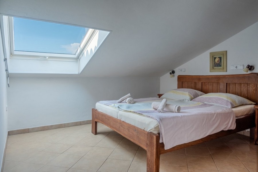 Spálňa s manželskou posteľou a strešným oknom