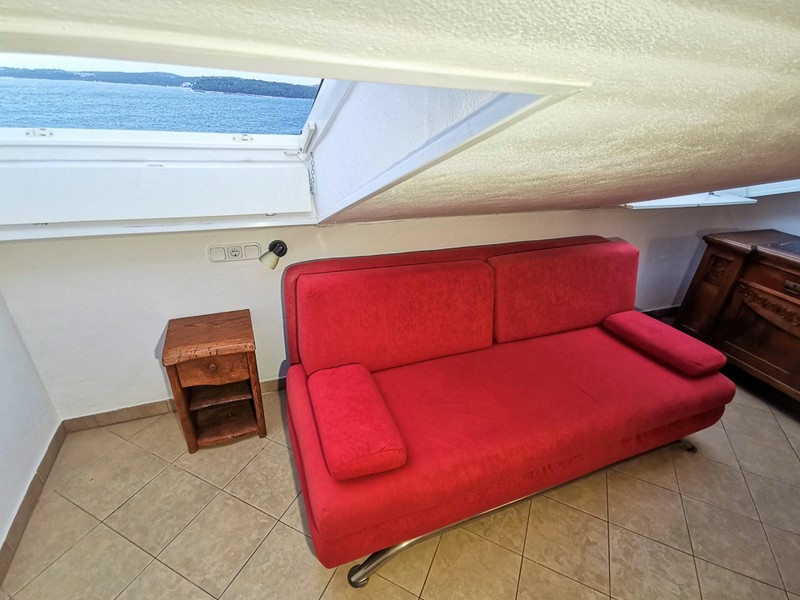 Posedenie s červenou pohovkou a výhľadom na more