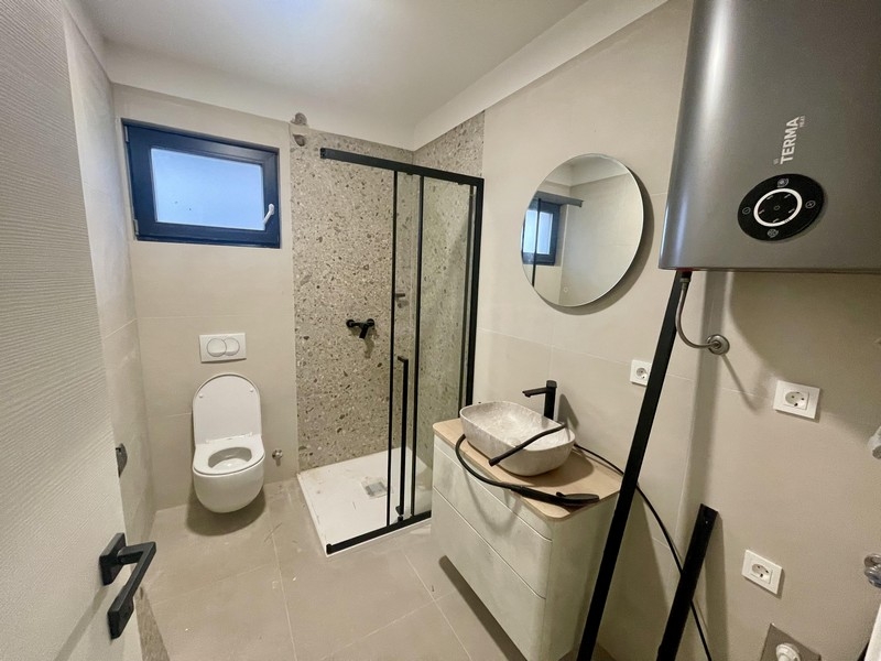 Moderná kúpeľňa so sprchovacím kútom v prízemnom apartmáne Omišalj