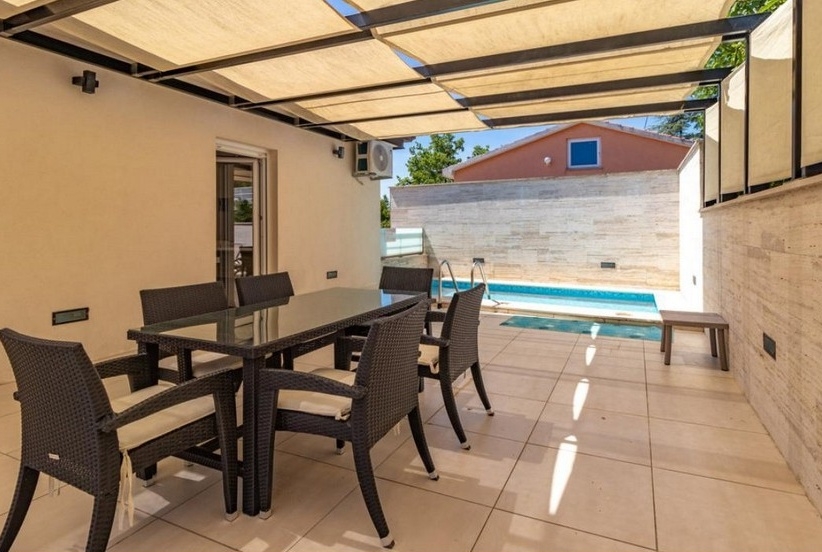 Krytá terasa s jedálenským kútom a výhľadom na bazén