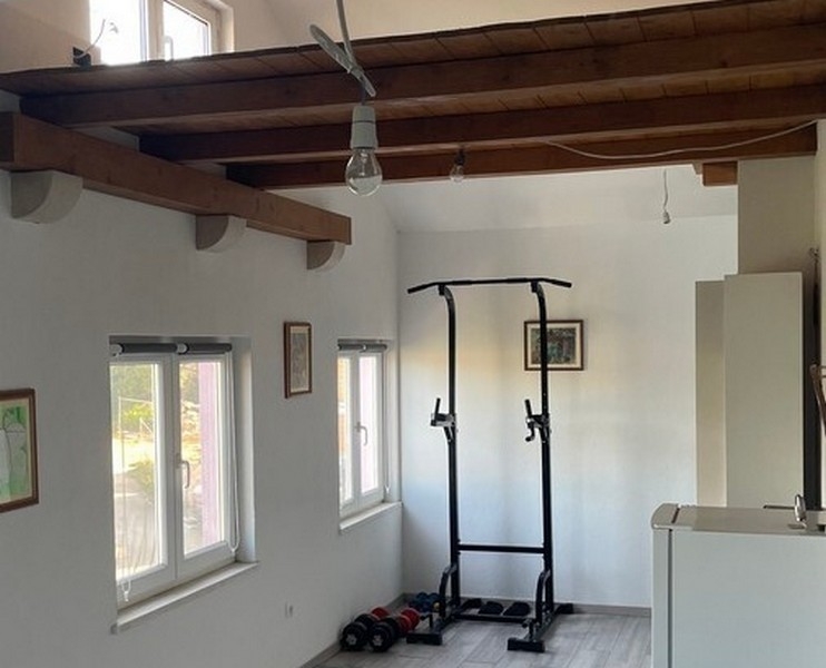 Fitness zóna pod drevenými trámami v obývacej izbe