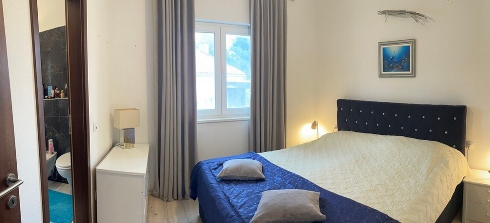 Spálňa s manželskou posteľou, oknom a prístupom do kúpeľne