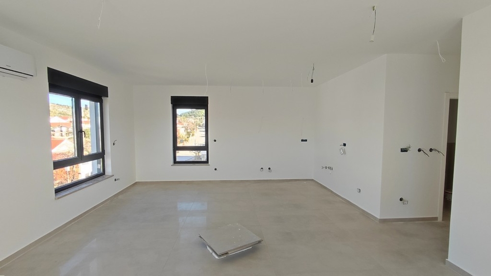 Svetlá obývačka nového bytu s veľkými oknami