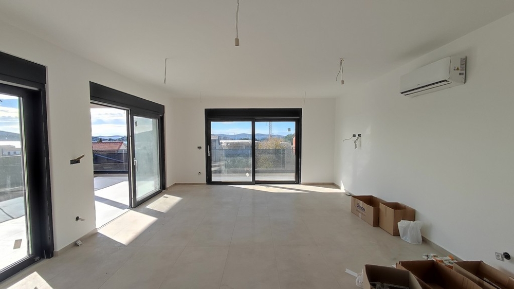 Priestranná obývacia izba s výhľadom na more a prístupom na niekoľko dverí na terasu