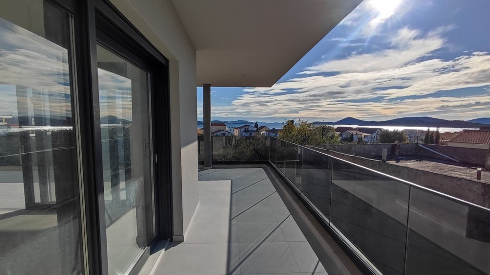 Balkón nového bytu so skleneným zábradlím a výhľadom na more