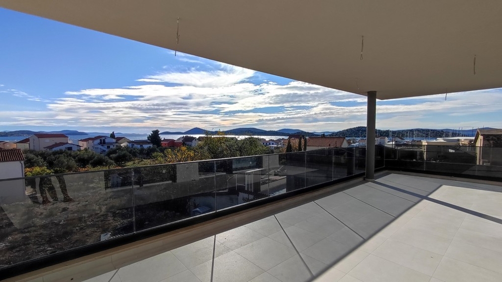 Veľká krytá terasa s výhľadom na strechy a more