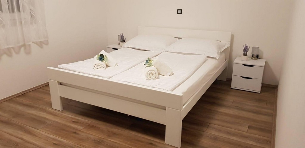 Spálňa s manželskou posteľou a nočným stolíkom