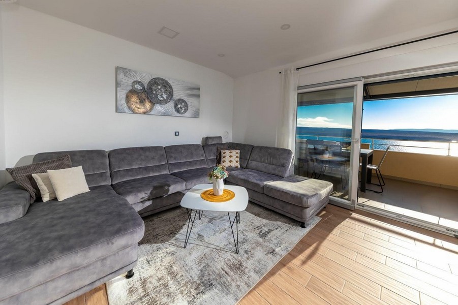 Obývacia izba s prístupom na terasu a výhľadom na more