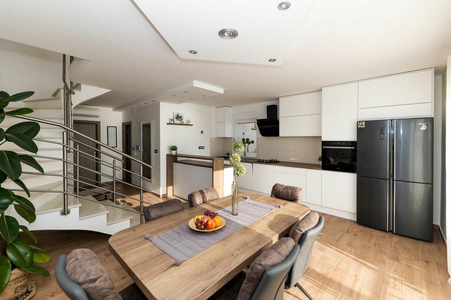 Otvorená kuchyňa s jedálenským kútom a schodiskom na poschodie