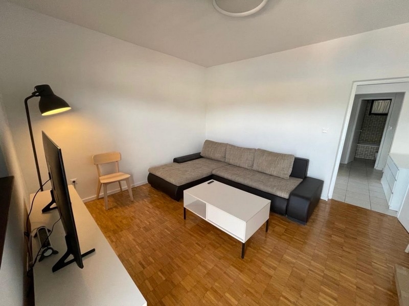 Obývacia izba s rohovou pohovkou a TV