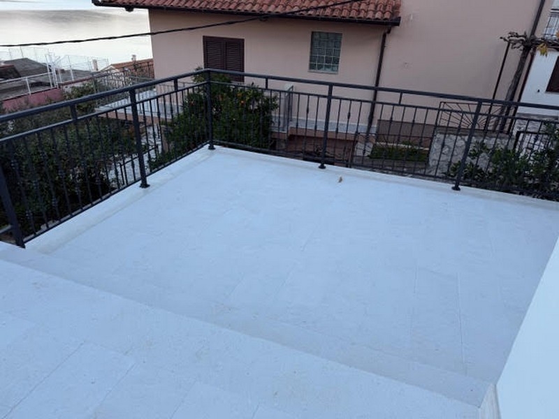 Terasa so zábradlím a výhľadom na susedný dom