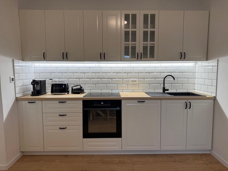 Svetlá kuchyňa s bielym vstavaným nábytkom