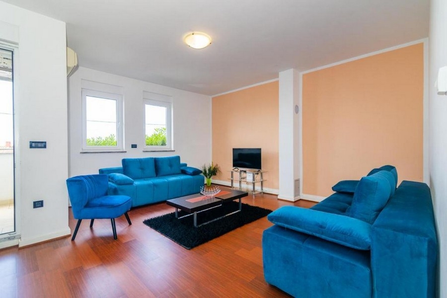 Obývacia časť s dvomi tyrkysovými pohovkami.