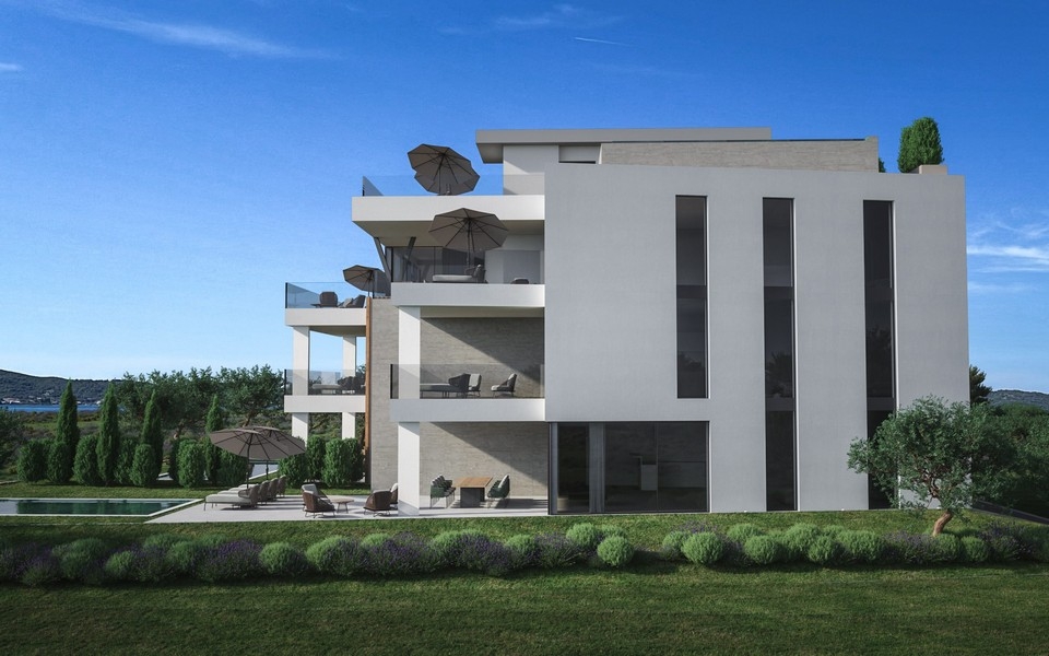 Pohľad zozadu na modernú novostavbu s terasami a výhľadom na more
