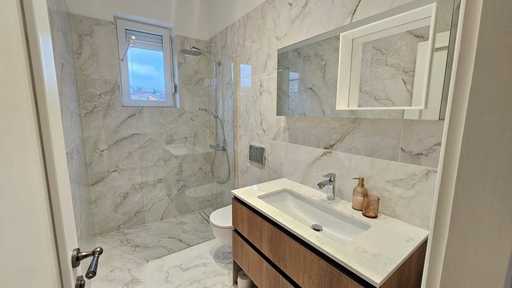 Moderná kúpeľňa so sprchovacím kútom na úrovni podlahy