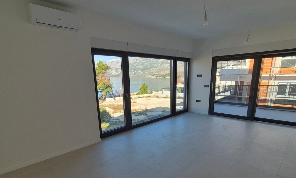 Obývacia izba s veľkými oknami a výhľadom na more