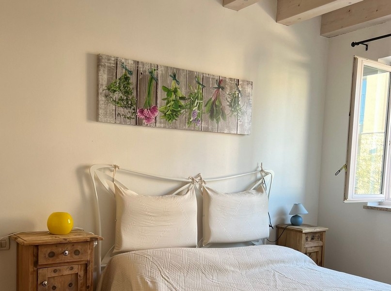 Spálňa s manželskou posteľou a dreveným stropom