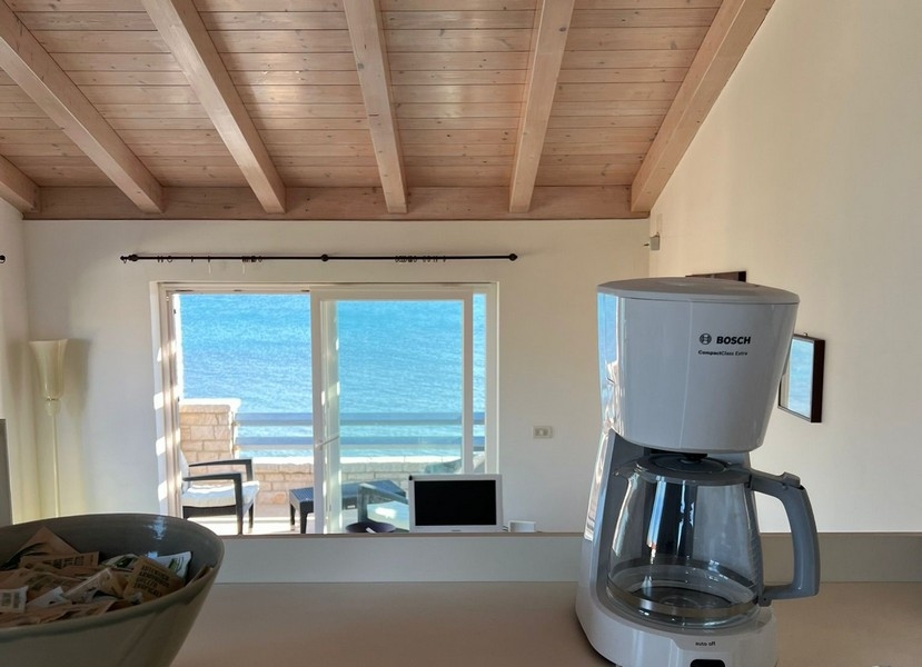 Výhľad z kuchyne cez obývací priestor na terasu a more