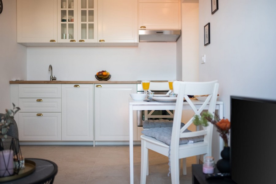 Biela kuchynka s drevenou pracovnou doskou