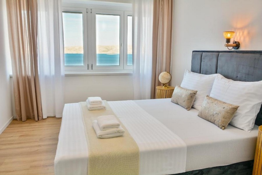 Spálňa s manželskou posteľou a výhľadom na more