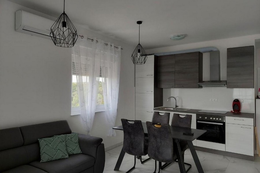 Otvorená obývacia a kuchynská časť s moderne vybavenou kuchyňou a jedálenským stolom