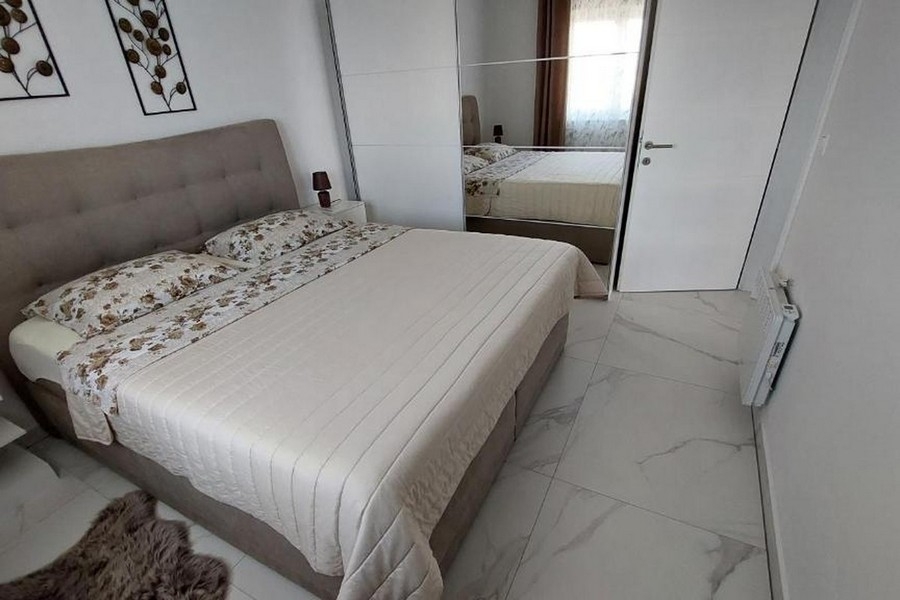 Spálňa s manželskou posteľou a šatníkovou skriňou so zrkadlovými dverami