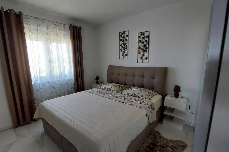 Spálňa s čalúnenou posteľou a oknom