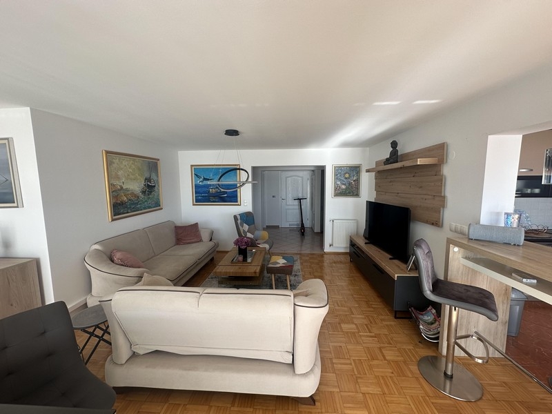 Obývacia izba s pohovkou a otvoreným prechodom do kuchyne