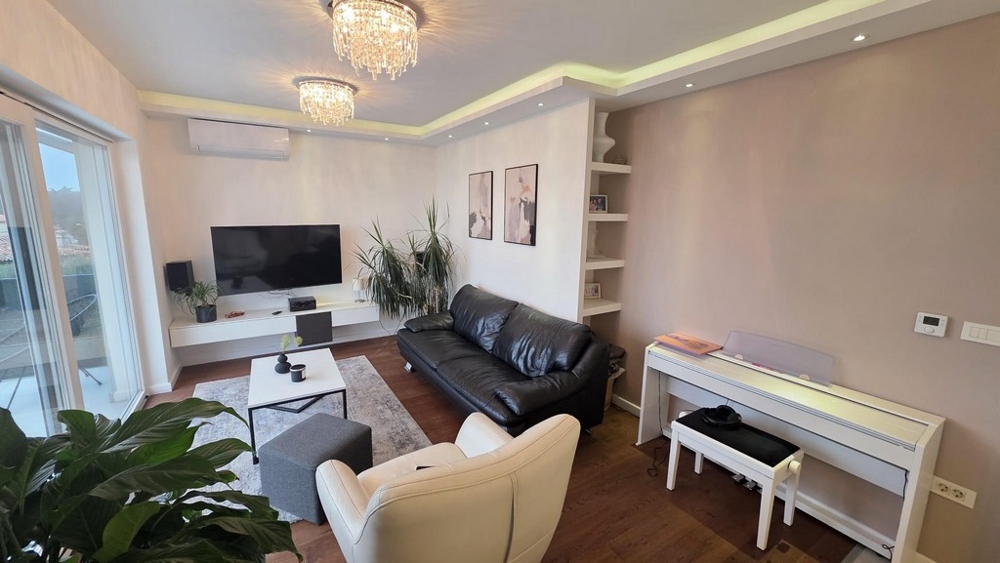 Moderná obývacia izba s koženou pohovkou, klimatizáciou a nepriamym osvetlením