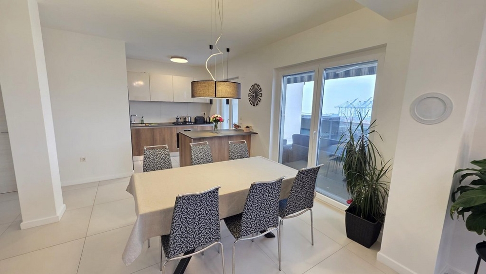 Jedálenský kút so stolom a šiestimi stoličkami a prístupom na terasu