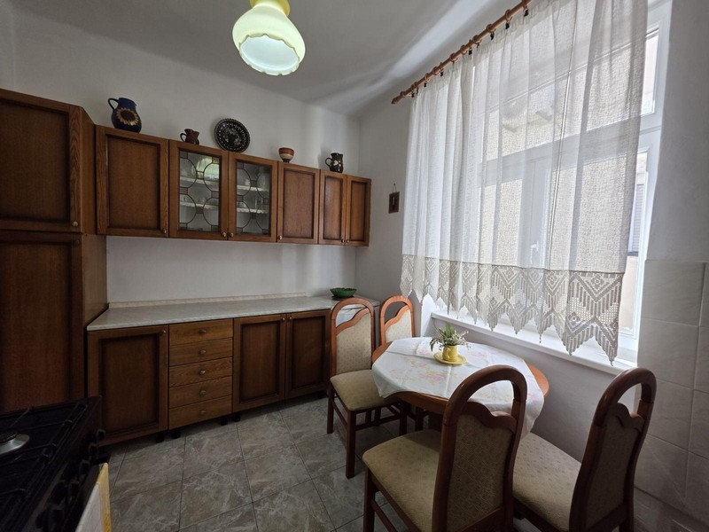 Kuchyňa s drevenými skrinkami a malým posedením