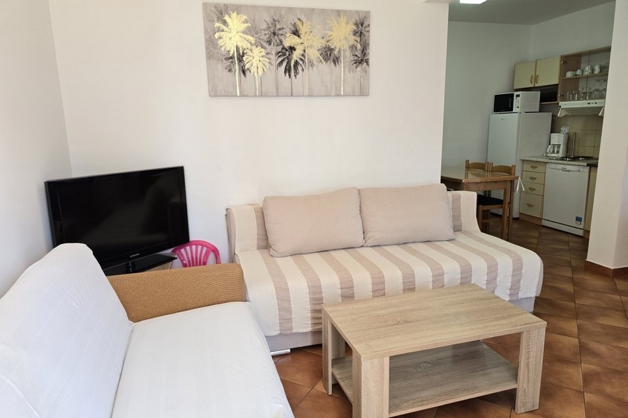 Obývacia izba s pohovkou, konferenčným stolíkom a TV