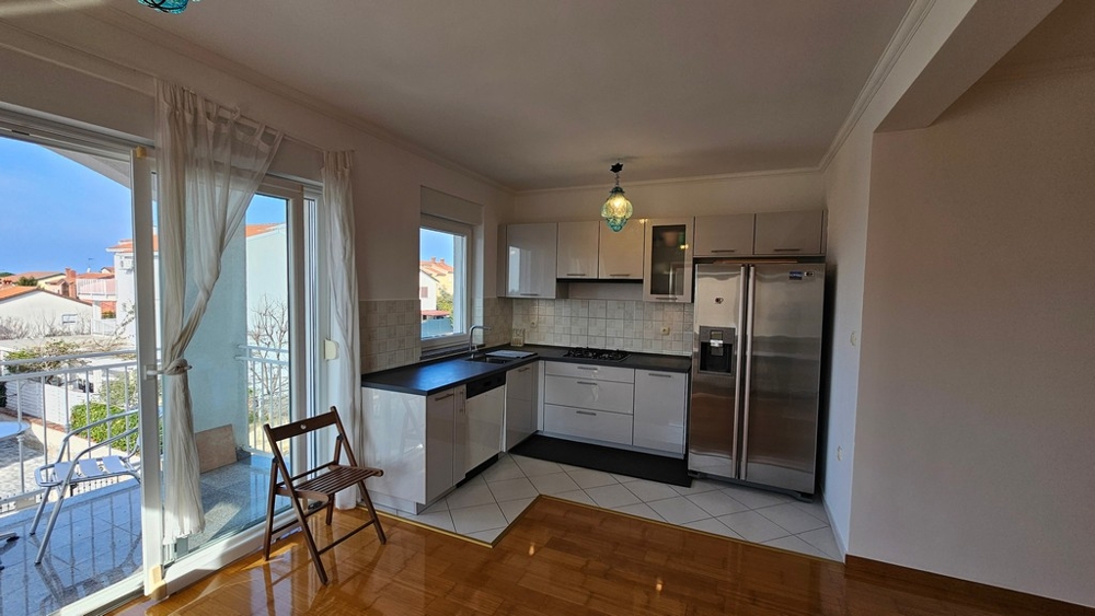 Obývacia izba s otvorenou kuchyňou a balkónom v meste Novigrad