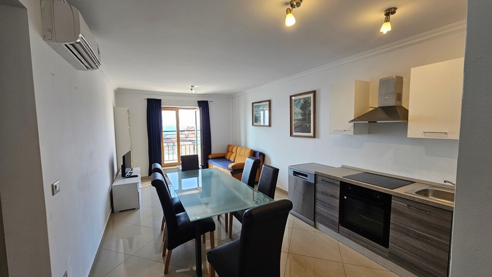 Svetlá obývacia izba s otvorenou kuchyňou, jedálenským kútom a výhľadom na more