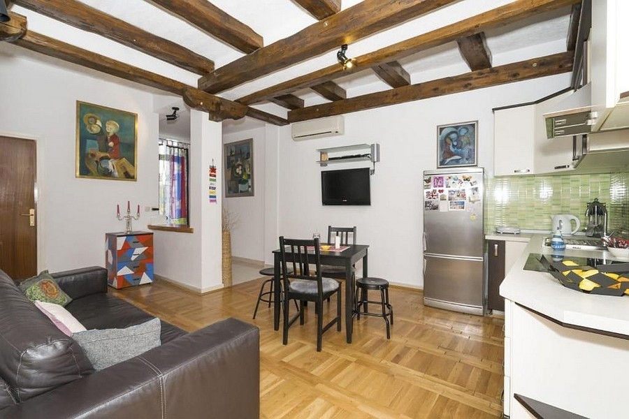 Obývacia časť s kuchyňou a jedálenským kútom a dreveným trámovým stropom