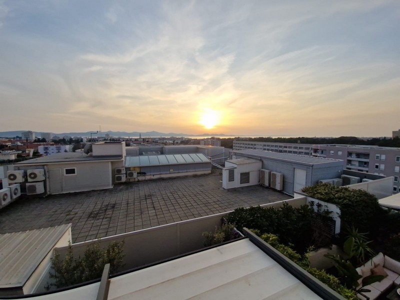 Výhľad na more nad mestom pri západe slnka