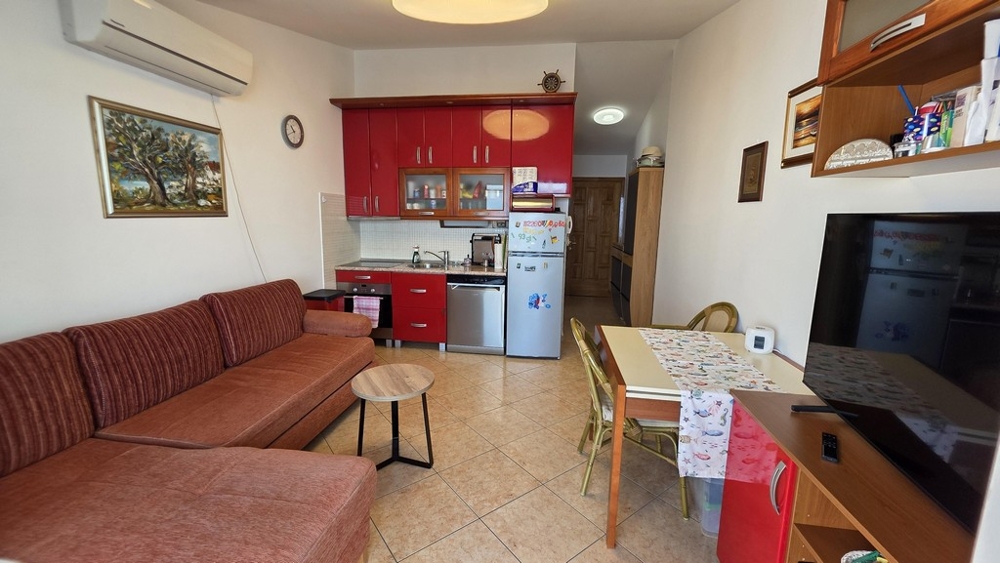 Obývacia izba s pohovkou a otvorenou kuchyňou