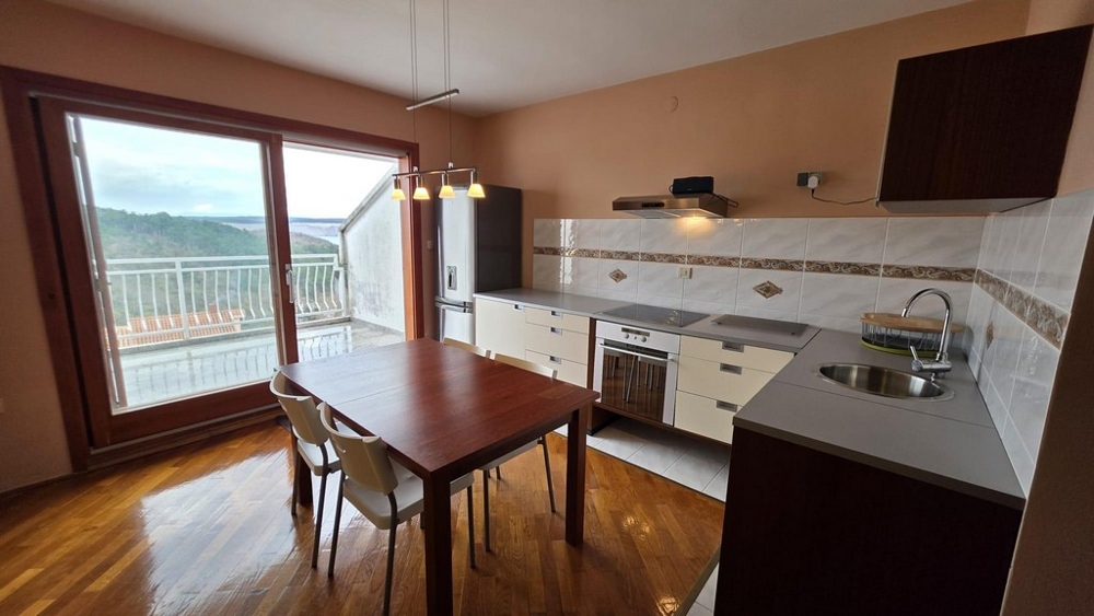 Obývacia časť s integrovaným kuchynským kútom a výhľadom na terasu.