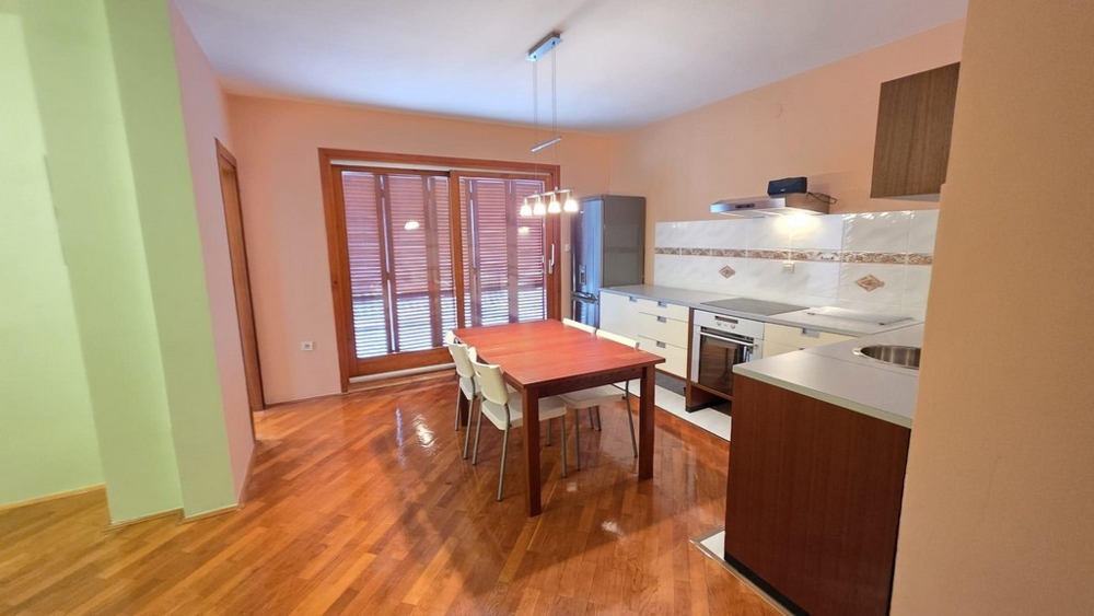 Obývacia časť s kuchyňou a jedálenským stolom a vstupom na balkón