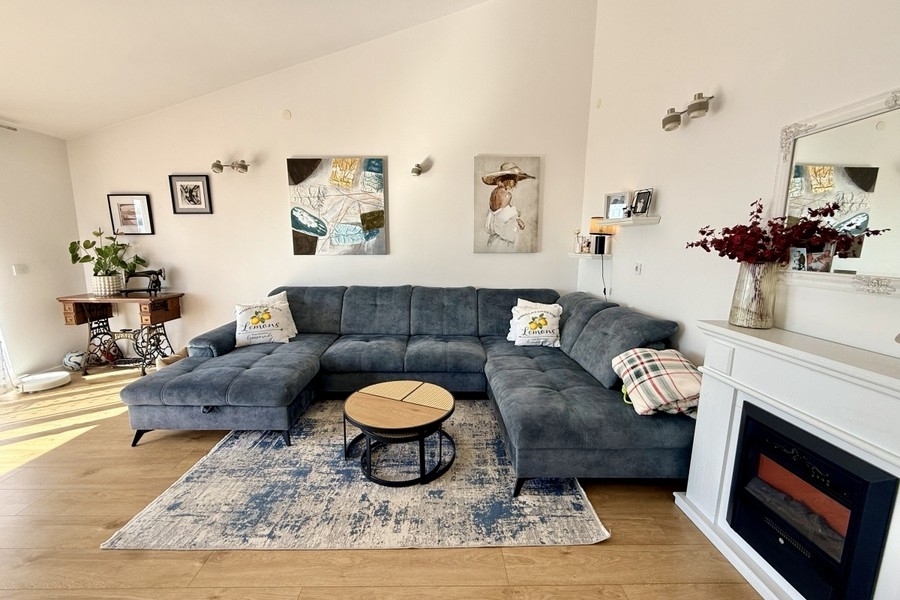 Svetlá obývacia izba s veľkým gaučom a moderným prostredím